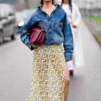 Steph Hui wears burgundy bordeaux oval Gucci sunglasses, silver earrings, navy blue oversized denim jean Gucci bomber jacket, a shiny burgundy...