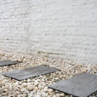 stepping stones and white brick wall - garden decoration stock pictures, royalty-free photos & images