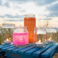 still life of lanterns and jars with tea lights for party decoration against marram grass, sea and sky - home decoration stock pictures, royalty-free photos & images
