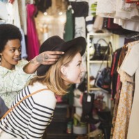 store owner trying hat on female customer in boutique - fashion stock pictures, royalty-free photos & images