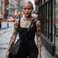 street portrait of a young, beautiful bald woman with many tattoos - fashion stock pictures, royalty-free photos & images