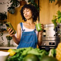 stylish home chef researches vitamin rich recipes on mobile for balanced nutrition plan - food stock pictures, royalty-free photos & images