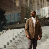 stylish man in brown jacket standing on modern urban steps outdoors - fashion stock pictures, royalty-free photos & images