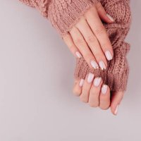 stylish pastel pink beige nails holding knitted wool material on hell background - nails art stock pictures, royalty-free photos & images