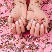 stylish pastel pink beige nails holding many multicolored sparkles - nails art stock pictures, royalty-free photos & images