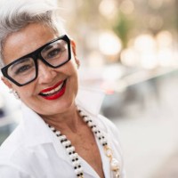 stylish senior businesswoman smiling outdoors with blurred city background - fashion stock pictures, royalty-free photos & images