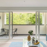 stylish show home living room of a contemporary apartment with open sliding doors onto a balcony - home decoration stock pictures, royalty-free photos & images