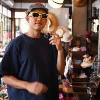 stylish thai man trying on sunglasses in a boutique - fashion stock pictures, royalty-free photos & images
