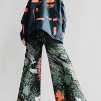 stylish woman wearing a multi-colored jacket and flare pants with black boots, is seen from the back abstract portrait - fashion stock pictures, royalty-free photos & images