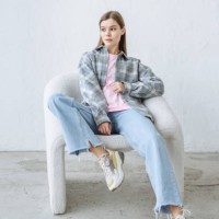 stylish young brunette woman posing sitting in a chair in casual clothes - fashion photos et images de collection