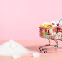 supermarket trolley with candy next to pile of sugar - junk food stock pictures, royalty-free photos & images