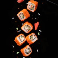 sushi pieces between chopsticks, flying separated on black background. - food stock pictures, royalty-free photos & images