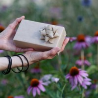sustainable lifestyle. gift box wrapped brown paper on blurred garden background - garden decoration stock pictures, royalty-free photos & images