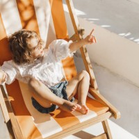sweet cute baby enjoying on sun bed or chaise lounge. summer children fashion style - fashion stock pictures, royalty-free photos & images