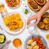 table filled with various dishes including chop suey, stuffed potatoes, fajitas, rice muffins, ricotta rolls and various salads - food stock pictures, royalty-free photos & images
