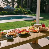 table, setting and food for lunch in backyard for social event, celebration and gathering by home. feast, patio and charcuterie board with burgers, salad and gourmet cuisine for outdoor dinner party - garden decoration stock 