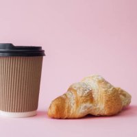 take away coffee in paper cup and croissant over pink background - junk food stock pictures, royalty-free photos & images