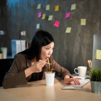 take instant noodles breaks while working in the office. - junk food stock pictures, royalty-free photos & images