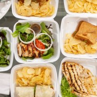 takeout food and containers full of sandwiches, salads and potatoe chips - junk food stock pictures, royalty-free photos & images