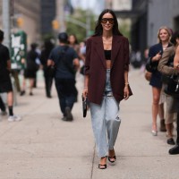 Tamara Kalinic is seen wearing large black shield-frame sunglasses with orange lenses and wide temples from Tom Ford, a long burgundy virgin wool...