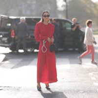 Tamara Kalinic is seen wearing long red dress, shoulder pads with side ruffles, silver chain and black leather handbag during the Stella McCartney...