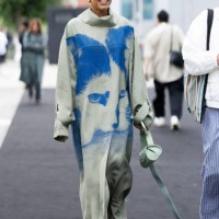 Tamu McPherson is seen wearing gold hoop earrings, a light olive green leather bag and a turtle neck light olive green oversized tracksuit with an...