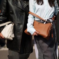 Tamu McPherson wearing a sleek black leather coat layered over a structured dress and a bag, Jenny Tsang wearing a shirt, a skirt, a bag and Proud...