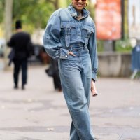 Tamu McPherson wears brown sunglasses, brown suede pumps and a denim cargo jumpsuit outside Zimmermann show during Womenswear Spring/Summer 2025 as...