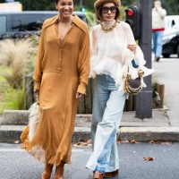 Tamu McPherson wears gold hoop earrings, a brown and beige fur bag, a beige long sleeved long shirt dress and brown leather heeled boots and on the...