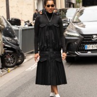 Tamu Mcpherson wears Maison Margiela shoes, Sacai dress and top and Prada sunglasses outside the Sacai show during Womenswear Spring/Summer 2025 as...