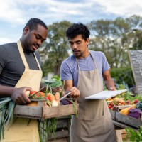 team of farmers selling organic vegetables at a farmer's market - food stock pictures, royalty-free photos & images