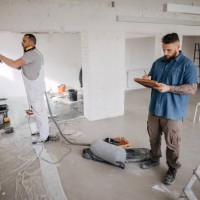 team of workers working on renovating the wall - home decoration stockfoto's en -beelden