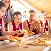 teenage basketball champions eating pizza after winning - junk food stock pictures, royalty-free photos & images