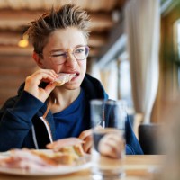 teenage boy eating a very tough sandwich - junk food stock pictures, royalty-free photos & images