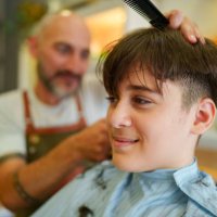 teenage boy having a haircut at the barber shop - hairstyle stock pictures, royalty-free photos & images