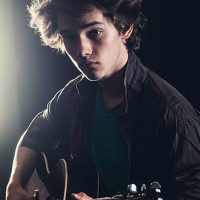 teenage boy playing acoustic guitar on stage - concert stock pictures, royalty-free photos & images