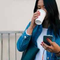 teenage girl drinking coffee while using mobile phone - junk food stock pictures, royalty-free photos & images