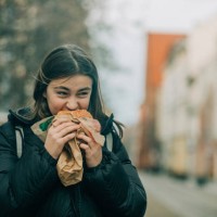 teenage girl eating burger on street - junk food stock pictures, royalty-free photos & images