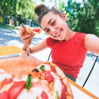 teenage girl taking a selfie while eating pizza - food stock pictures, royalty-free photos & images