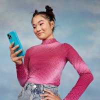 teenage girl using mobile phone while standing against colored background - fashion stock pictures, royalty-free photos & images