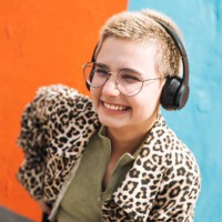 teenage girl with short hair in leopard jacket with headphones listens to music against bright wall - fashion stock pictures, royalty-free photos & images