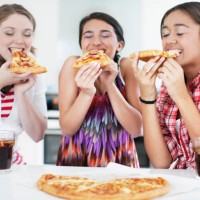 teenage girls eating pizza - junk food stock pictures, royalty-free photos & images