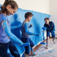 teenage kids having fun painting the room - home decoration stockfoto's en -beelden