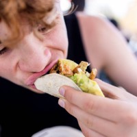 teenager boy is eating a chicken taco - food stock pictures, royalty-free photos & images