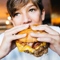 teenager eating a burger - food stockfoto's en -beelden