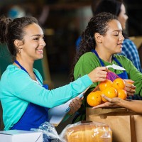 teenagers passing out donations at food bank donation drive - food stock pictures, royalty-free photos & images