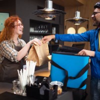 the delivery man picks up orders at the restaurant and packs them in a bag. - junk food stock pictures, royalty-free photos & images