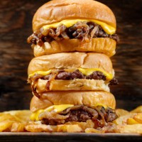 the famous fried onion smash burger with cheese and fries - junk food stock pictures, royalty-free photos & images