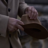the hands of a handsome man with a beige fashionable hat. a man in a historical costume of the 30s -40s of the 20th century, in a beige coat and a black turtleneck holds a hat in his hands. - fashion stock pictures, royalty-f
