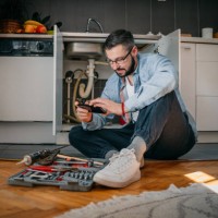 the plumber uses the phone - home decoration stockfoto's en -beelden